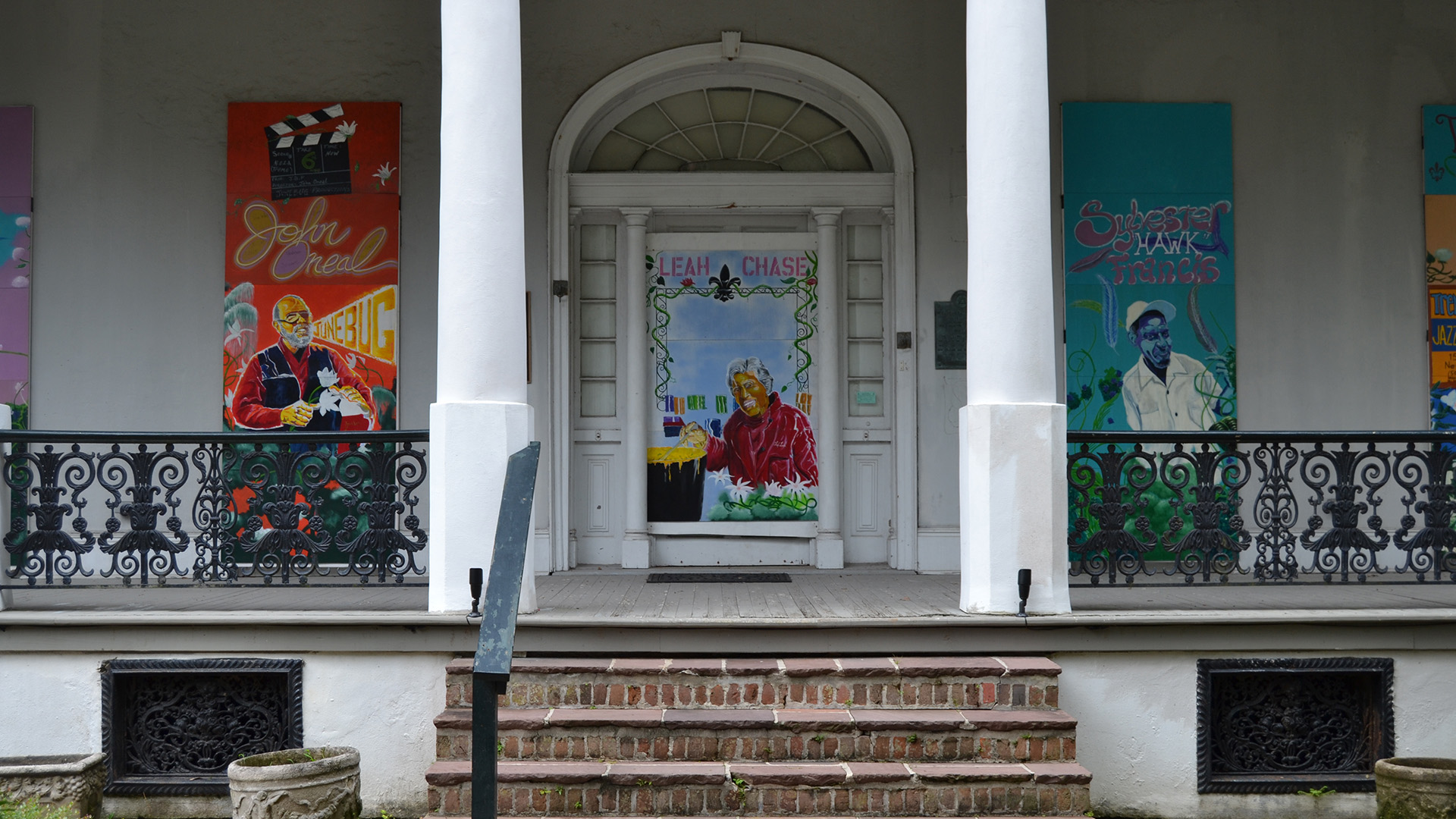 A photograph of Villa Meilleur with windows boarded up with artwork